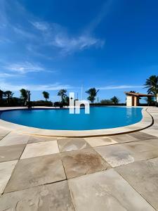 a swimming pool with a blue sky in the background at Casa - Summerville Cumbuco I By Inspira Ceará in Guagiru