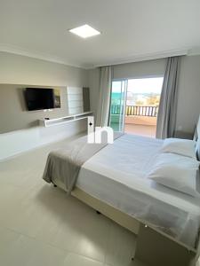 a white bedroom with a large bed and a tv at Casa - Summerville Cumbuco I By Inspira Ceará in Guagiru