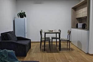 a living room with a table and chairs and a refrigerator at Penzión Drienok in Mošovce