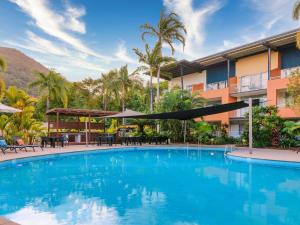 a swimming pool in front of a hotel at The Sebel Palm Cove in Palm Cove
