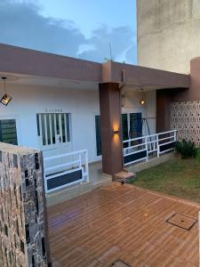 a house with a wooden deck and a building at Chambre salon avec cour privée in Porto-Novo