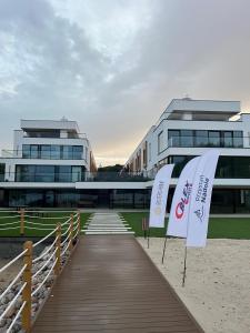 a building with two flags on a boardwalk at Apartament Przystań Nadole in Nadole