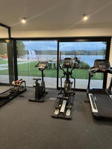 a gym with three treadmills and a large window at Apartament Przystań Nadole in Nadole