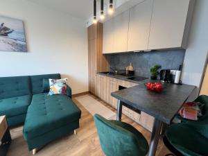 a living room with a green couch and a table at Apartament Przystań Nadole in Nadole +15 photos