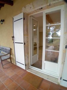 an open door to a patio with a bench at Gite de la Mouline in Lectoure +38 photos