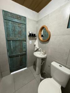 a bathroom with a toilet and a sink and a mirror at Céu - Quarto com entrada privada in Luis Correia