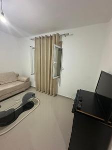 Una sala de estar con un sofá y un televisor. en Vila Apartment with garden, en Sarandë