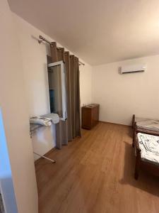 Cette chambre dispose de deux lits et de parquet. dans l'établissement Vila Apartment with garden, à Saranda