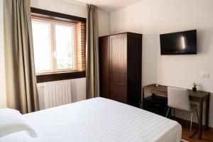 a bedroom with a bed and a desk and a window at Tenuta Madre Vita in Syracuse