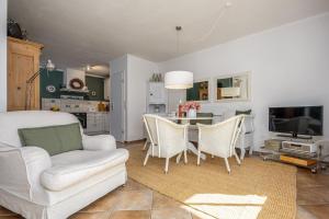 een woonkamer met een bank en een tafel met stoelen bij Born - Wieck Ferienwohnung Wildrose in Wieck