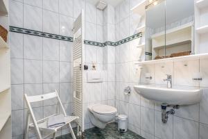 een witte badkamer met een wastafel en een toilet bij Born - Wieck Ferienwohnung Wildrose in Wieck +18 foto's