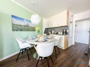 Una cocina y un comedor con mesa y sillas. en Watt n Blick 220, en Döse
