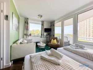 una habitación de hotel con dos camas y un sofá en Watt n Blick 220, en Döse 28 fotos más