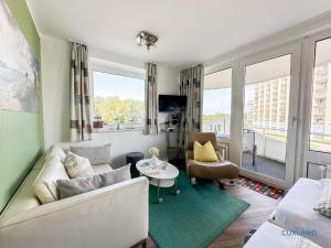 una sala de estar con un sofá y una mesa en Watt n Blick 220, en Döse