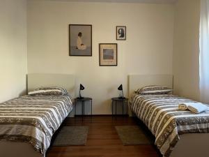 two beds in a room with two lamps on tables at Apartman Nika in Drniš