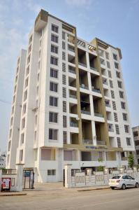 ein großes weißes Apartmenthaus mit einem Auto vor dem Haus in der Unterkunft Rk Stay 2bhk Balewadi Highstreet Fully Furnished Premium in Pune