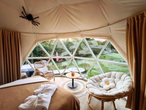 a bedroom with a tent with a bed and a chair at Dôme Saint-Eloi in Floursies