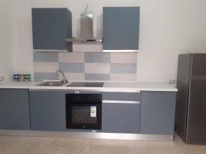 a kitchen with blue cabinets and a sink and a refrigerator at La Rotonda in Diamante +5 photos