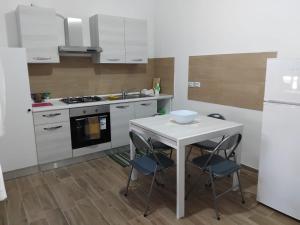 a kitchen with a table with chairs and a stove at La Rotonda in Diamante