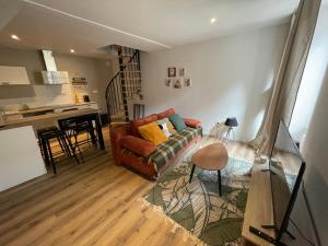 a living room with a couch and a kitchen at Gîte De la Cour au Grenier 2 in Chauvigny +13 photos