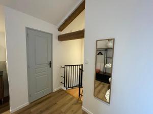 a hallway with a white door and a mirror at Gîte De la Cour au Grenier 2 in Chauvigny