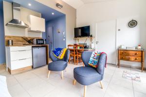 a living room with two chairs and a kitchen at Bed and Breakfast La Villa D'Elejack in Têche