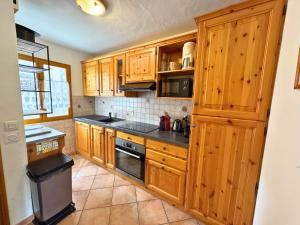 a kitchen with wooden cabinets and a stove top oven at Chalet 5 pièces, 8 pers, au coeur de St Martin de Belleville, proche pistes et commodités - FR-1-452-65 in Saint-Martin-de-Belleville +9 photos