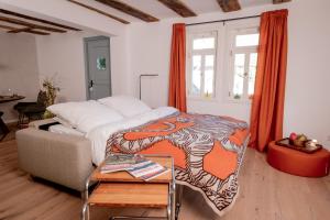 a bedroom with a bed and a couch and a table at Zur Traube - grün in Erbach +35 photos