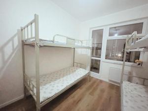 una habitación con dos literas y una ventana en Sunrise Guesthouse UB, en Ulán Bator