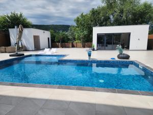 ein Swimmingpool mit blauem Wasser in einem Hof in der Unterkunft La Villa Luxury Home Bihac in Bihać