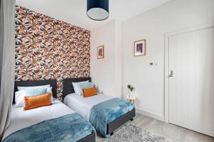 2 Betten in einem Zimmer mit einer Wand in der Unterkunft Edegely House in Stockport
