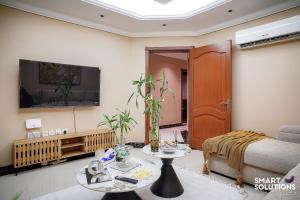 a living room with a couch and a tv at Twleen luxury 408 in Jeddah