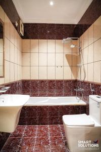 a bathroom with a tub and a toilet and a sink at Twleen luxury 408 in Jeddah +22 photos