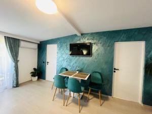 a dining room with a table and green chairs at Antonia home in Târgu-Mureş