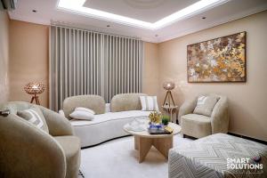 a living room with a couch and chairs and a table at Twleen luxury 408 in Jeddah