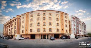 a large brick building with cars parked in front of it at Twleen luxury 408 in Jeddah