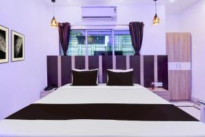 - une chambre dotée d'un grand lit avec des draps noirs et blancs dans l'établissement Hotel O Stay Inn, à Kolkata