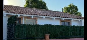 a white house with a fence in front of it at Casa rural privada y cabañas Hasta 12 plazas in Orihuela
