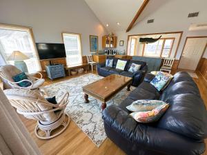 a living room with a leather couch and a table at N2102- Sunny Daze in Nags Head