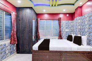 a bedroom with a bed with red and blue walls at Hotel O Blue Star Hotel & Restaurant in Bārāsat