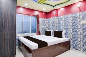 a bedroom with a bed with a red wall at Hotel O Blue Star Hotel & Restaurant in Bārāsat