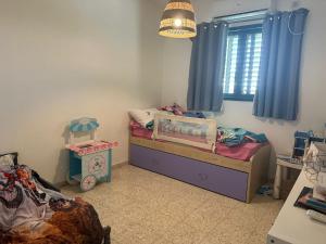 a small bedroom with a bed and a window at Tal Shahar Extension in Tal Shaẖar