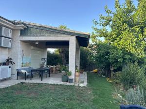 a patio with a table and chairs in a backyard at Tal Shahar Extension in Tal Shaẖar
