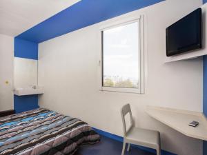 a room with a bed and a desk and a window at hotelF1 Nantes Est La Beaujoire in Nantes