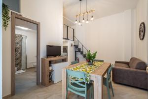 a dining room and living room with a table and chairs at Loft San Basilio in Palermo