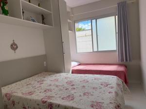 a small bedroom with a bed and a window at Apto 2 Quartos Perfeito in Guarapari