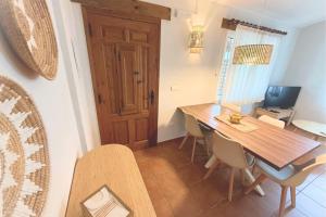 una sala da pranzo con tavolo e sedie in legno di La Font, un bungalow cerca del mar, alegre y acogedor - La Font, Villa Sabrina Resort a El Perelló