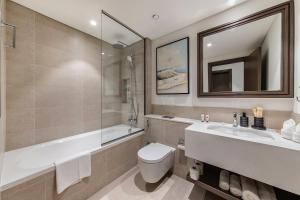 Un baño con inodoro, lavabo y bañera. en JBR Beach Front Apartment, en Dubái 45 fotos más