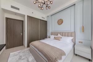 Un dormitorio con una cama grande y una lámpara de araña. en JBR Beach Front Apartment, en Dubái