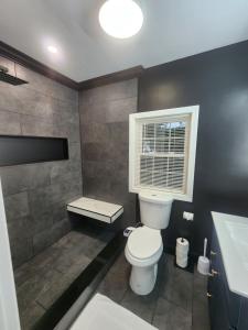 a bathroom with a toilet and a sink and a window at Otter's Paradise in Gardner